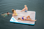 Four friends on the Party Cove Dock, with one swimming nearby. The floating dock has a woodgrain print and blue trim.