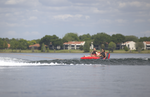 Two riders sit back on the Big Easy 2 towable tube, gliding across the water behind a boat.