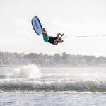 Wakeboarder performing an aerial trick over the water, holding the handle while riding the Bio wakeboard.