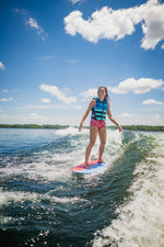 Young rider carving on the DASH Kid's Board, balancing on the wake while wearing a blue life vest.