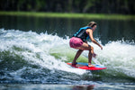 Young surfer crouching low on the DASH Kid's Board, maintaining balance on a breaking wave.