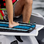 Close-up of a rider’s foot pressing against the Scout wakesurf board’s raised rear traction pad.