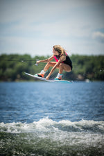 Action shot of a rider performing an aerial trick on the Wild Child wakeboard over the water.