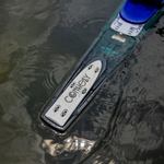 Tail of 2024 Women's Concept waterski floating in water, showing metal plate with engraved Connelly logo and fin placement.