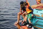 A young rider prepares to hit the water, strapped into the 2024 Charger Kids' Wakeboard, ready for action.