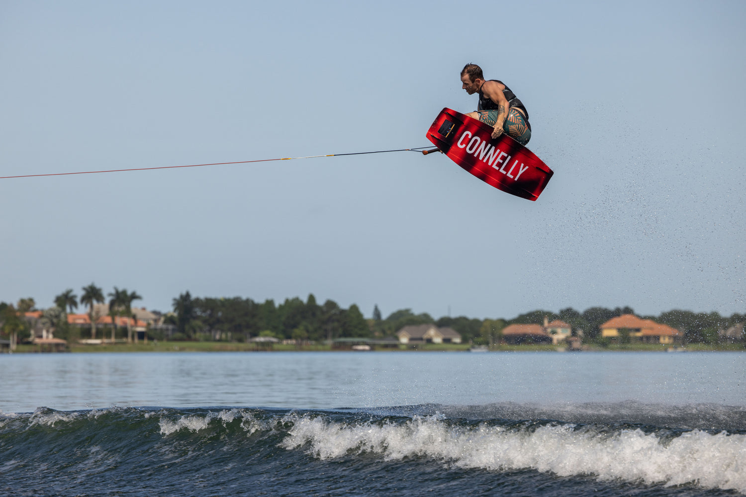 Rider performing an aerial trick on a Connelly 2023 Standard wakeboard, demonstrating power, agility, and performance.