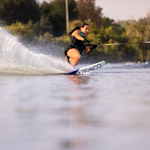 Female waterskier carves through the water on the Connelly Women's Concept ski, creating a dramatic spray from the wake.