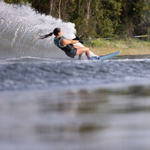 Female waterskier leans into a hard turn on the Connelly Women's Concept ski, leaving a wide arc of water spray behind.